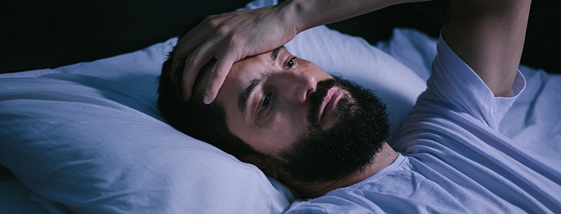 Exhausted man lying in bed