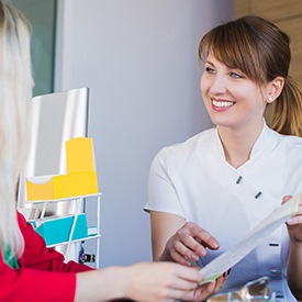 Patient getting paperwork at reception desk