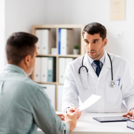 Doctor and patient sitting at desk, talking
