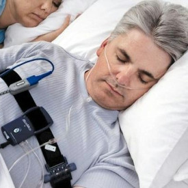 Man sleeping while wearing ResMed testing equipment