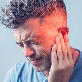 Man in pain holding ear