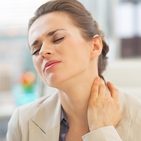 Woman holding neck in pain