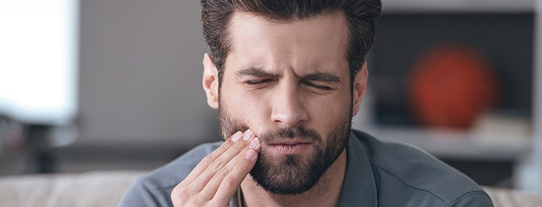 Man in pain holding jaw