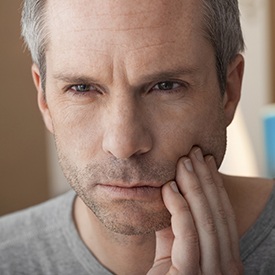 Man holding jaw in pain