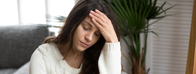 Frustrated woman with head in hands