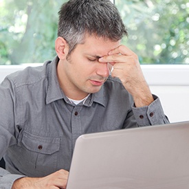 Man with headache holding his head