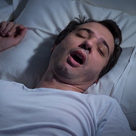 Man snoring in bed