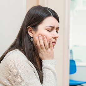 Woman holding cheek in pain