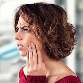 Woman holding jaw in pain