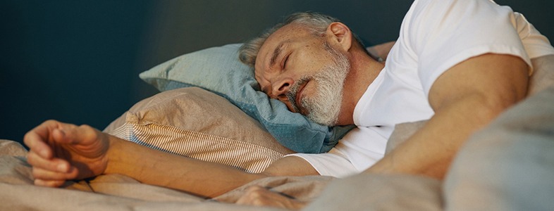 Mature man peacefully sleeping in bed