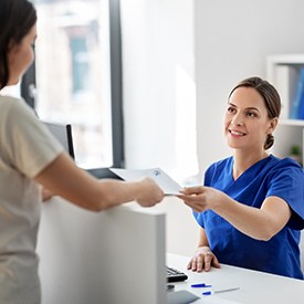 Sleep apnea team member handing paperwork to patient
