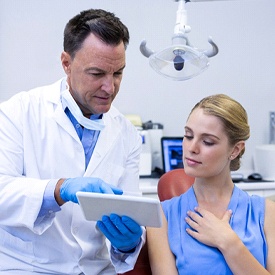 A dental professional explaining how an oral device will work to a female patient receiving sleep apnea therapy