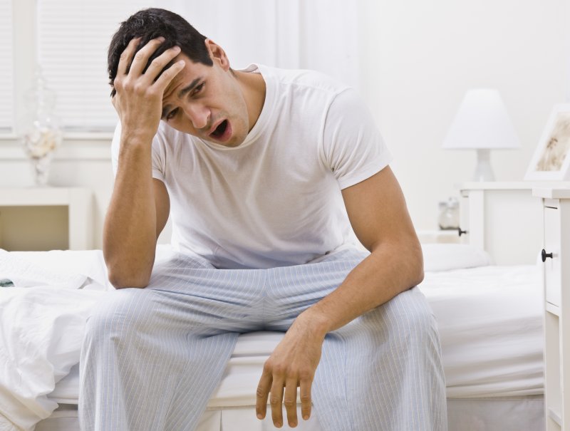 A man yawning in bed.