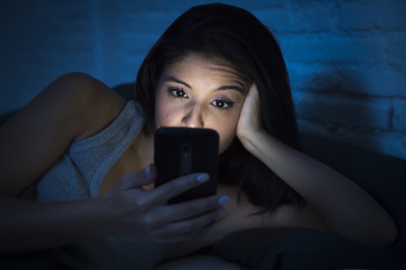 A woman using her phone at night.