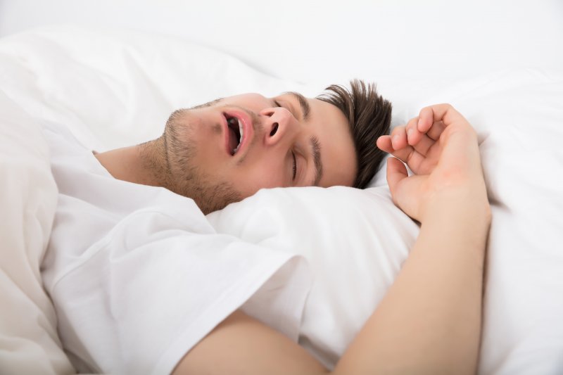 Young man lying on pillows and snoring