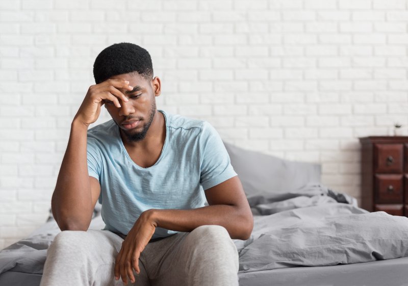 Man with sleep apnea and depression sitting on bed