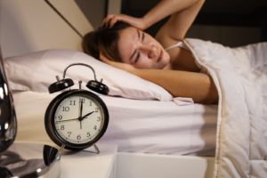 Woman struggling with sleep apnea symptoms early in the morning