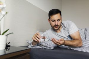 Man preparing to take sleeping pills before bed