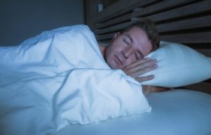 Man sleeping peacefully with oral appliance from sleep dentist