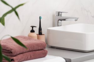 Bathroom sink next to soap and toothbrush, ready for cleaning oral appliance