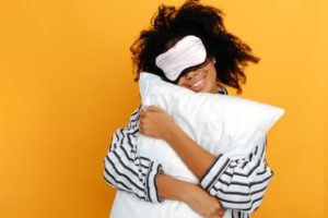 Woman holding pillow, establishing bedtime routine for sleep apnea