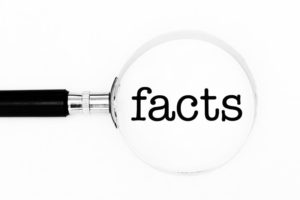 Magnifying glass showcasing the word “facts”