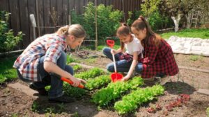 Mother with her two daughters working in garden 