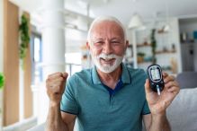 A man holding a blood sugar monitor.